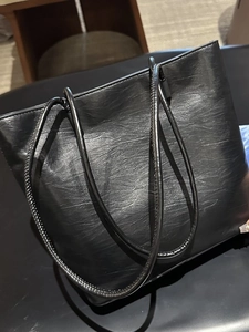 Large black faux leather tote bag with stylish pleated texture and dual shoulder straps