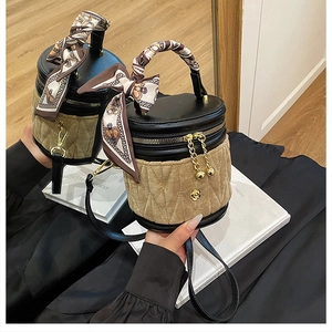 Detail einer Vintage-Eimertasche mit gestepptem Samt, Seidenschal-Griff und Gold-Beschlägen