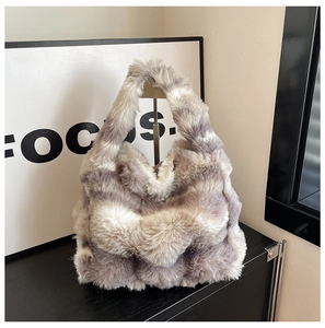 Détail de la texture en fausse fourrure grise et blanche et de l'anse de ce sac d'hiver