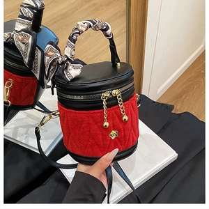 Detail der roten gesteppten Beuteltasche mit Goldbeschlägen und Seidenschal am Griff
