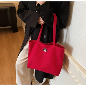 Detail of red canvas tote bag with a cute puppy embroidery on a classic shoulder bag