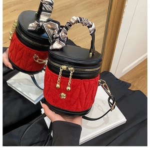 Detailaufnahme der roten Samt-Eimertasche mit Rautensteppung und Seidenschal-Griff