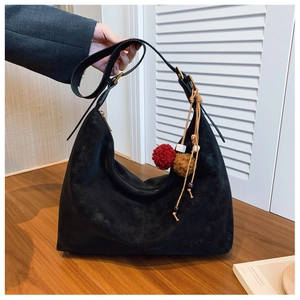 Detail der schwarzen Wildleder-Hobo-Tasche mit MEEFIL-Logo und handgemachtem Anhänger