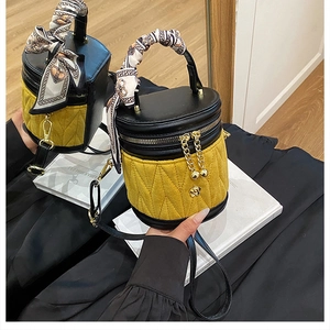 Detail der gelben Stepptasche mit Seidenschal-Griff und goldener Kettenquaste