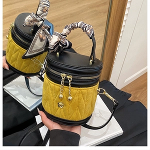 Detail der gelben gesteppten Beuteltasche mit Seidenschal-Griff und goldenem Logo