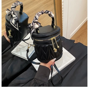 Detail der schwarzen Stepp-Eimertasche mit Seidenschal-Griff und Gold-Hardware