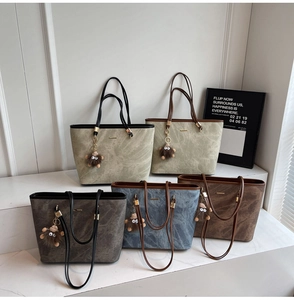 Detailed close-up of colorful suede tote bags with cute monster charms in five neutral shades