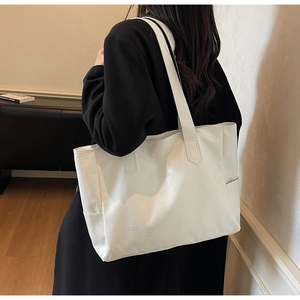Detail view of large cream tote bag with side pocket and NOCEBAG minimalist logo