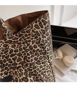 Detail of leopard print canvas tote bag featuring soft fabric and spacious brown lining