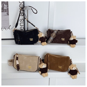 Détail de sacs polochons vintage en quatre couleurs avec larges bandoulières et oursons en peluche