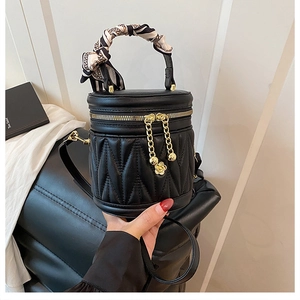Details der schwarzen Stepptasche mit Kamelien-Reißverschluss und Seidenschal-Griff