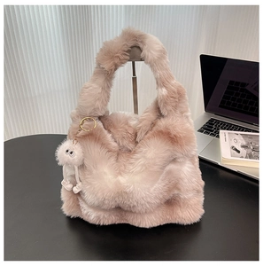 Détail du sac fourre-tout en peluche dégradé marron avec un joli petit pendentif blanc