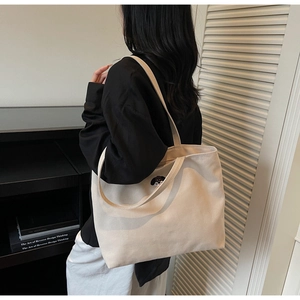 Detail of beige canvas tote bag with cute puppy embroidery in a lifestyle setting