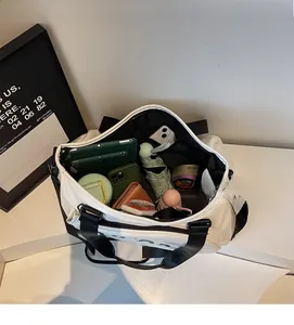 Geräumiges Innenfach der weißen Canvas-Fitnesstasche mit Tablet, Schirm und Zubehör