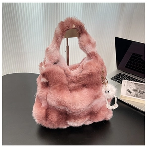 Détail d'un sac cabas rose en fausse fourrure avec breloque peluche et poignée souple