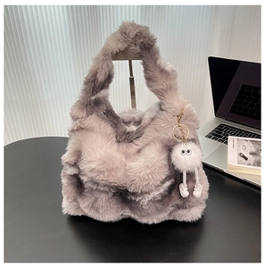Détail du sac cabas en peluche grise avec un charmant pendentif blanc en fourrure