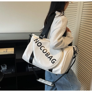 Detail der weißen Leder-Reisetasche mit großer Kapazität und NOCOBAG-Schriftzug in Schwarz