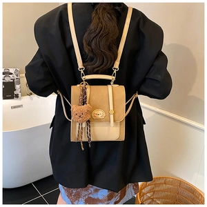 Detailansicht eines Patchwork-Rucksacks in Beige und Hellbraun mit süßem Teddybär-Anhänger