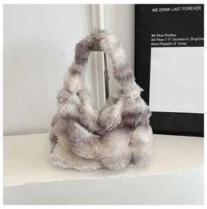 Vue détaillée de la texture en fausse fourrure pelucheuse d'un sac cabas dégradé gris et blanc