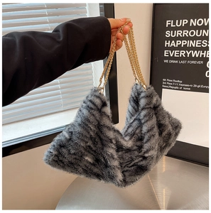 Détail du sac cabas en fausse fourrure à rayures grises avec doubles anses dorées