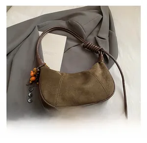 Detail of vintage brown suede dumpling bag with wooden beads and stylish knotted strap