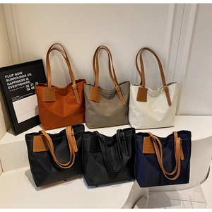 Detailed display of large capacity nylon tote bags in diverse colors with leather straps
