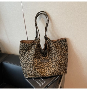 Close-up of leopard print canvas tote bag showing front pocket detail and durable handles