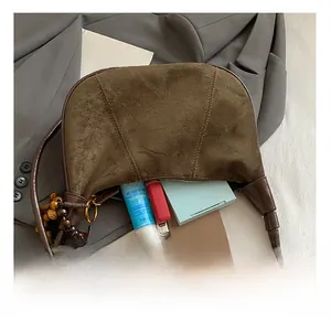 Detail of vintage brown suede shoulder bag showing interior capacity with essentials