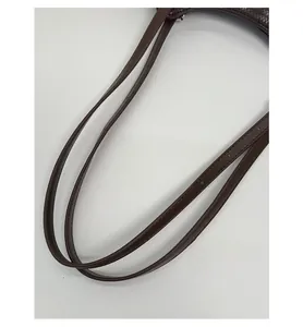 Détail des bretelles en cuir tressé marron avec coutures soignées sur un sac cabas