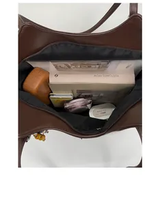 Vue de dessus de l'intérieur du grand sac cabas marron avec livres et cosmétiques