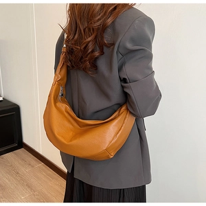 Sac bandoulière en cuir PU marron porté par un mannequin avec zip argenté