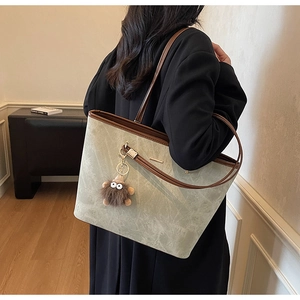 Detailed close-up of a large tote bag with marble texture and contrasting brown leather straps