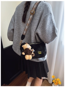 Détail du sac à bandoulière noir avec sangle brodée et pendentif ours mignon