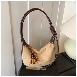 Detail of vintage suede shoulder bag with wooden bead zipper pull and knotted strap