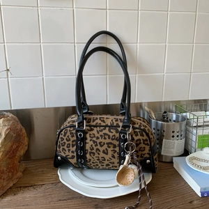 Close-up of leopard print Boston bag with black leather trim and metal ring details