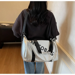 Silberne Metallic-Tasche mit schwarzem Gurt an der Schulter zur Größenreferenz
