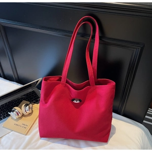 Detail of red canvas tote bag with cute dog embroidery in a lifestyle setting