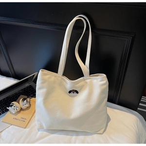 Detailed embroidery of a cute puppy on a minimalist white canvas tote bag with long straps