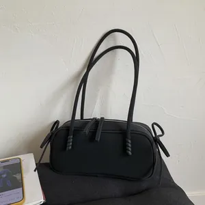 Détail du sac polochon noir mat en nylon avec nœuds en corde et nœuds papillon chic