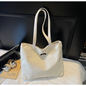 Close-up of white canvas tote bag with cute dog embroidery and long shoulder straps