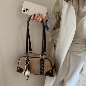 Detail of vintage brown suede Boston bag with leather trim and baseball glove charm
