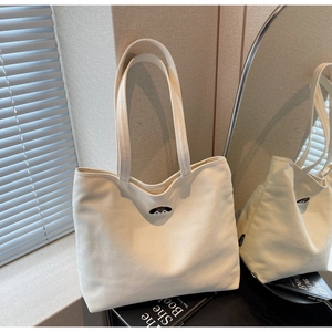 Detail of cute dog embroidery and woven label on cream canvas tote bag for women