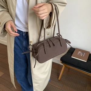 Détail du sac à bandoulière marron mat avec nœuds et fermeture éclair métallique