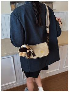 Détail du sac oreiller beige en daim avec bandoulière jacquard et charm ours en peluche
