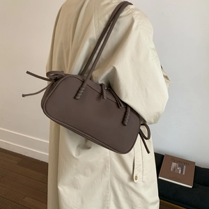 Vue détaillée du sac bandoulière en cuir mat café avec des nœuds à franges décoratifs
