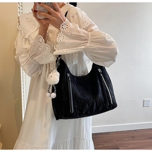 Detail of black wrinkled nylon Hobo bag with double zippers and cute plush cloud charm