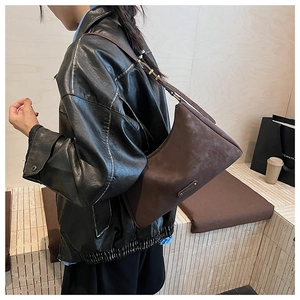 Detail shot of vintage dark brown crossbody bag with matte texture and metal plate
