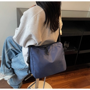 Blue plaid large capacity tote bag shown on model with adjustable strap and zip closure