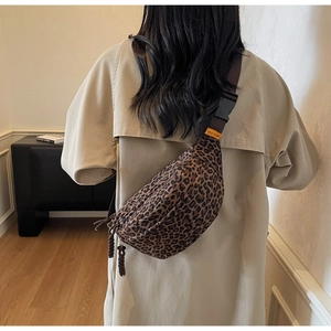Detail of leopard print crossbody bag featuring adjustable strap and secure plastic buckle