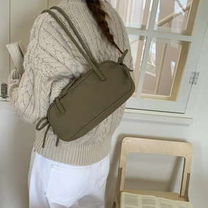 Sac à épaule cylindrique en cuir mat vert olive avec nœuds tressés et franges